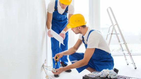 A two electrician fixing the outlet.