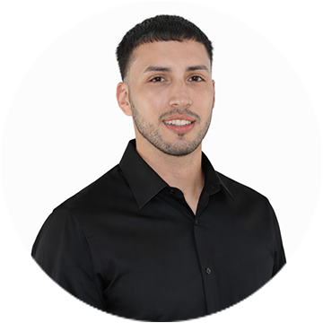 A person wearing a blue checkered sleeve smiling.